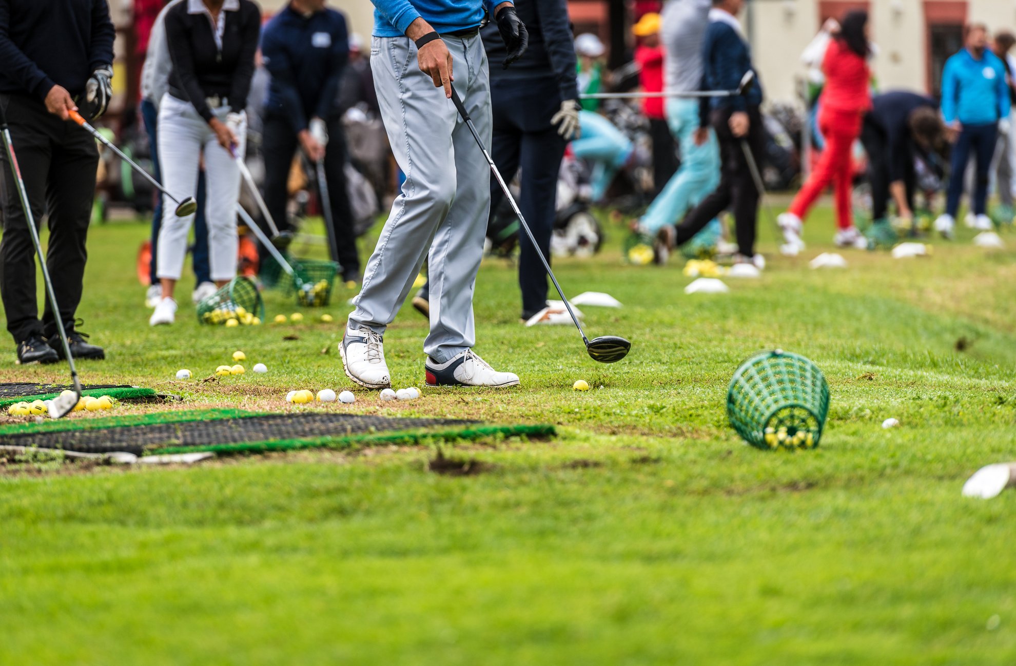 Golfer legs at golf tournament practice swing with golf club.